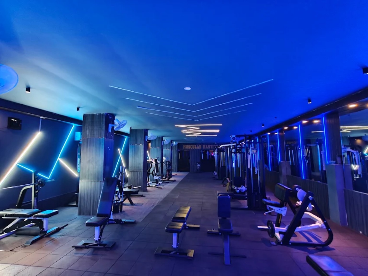 Blue-lit gym floor with training equipment